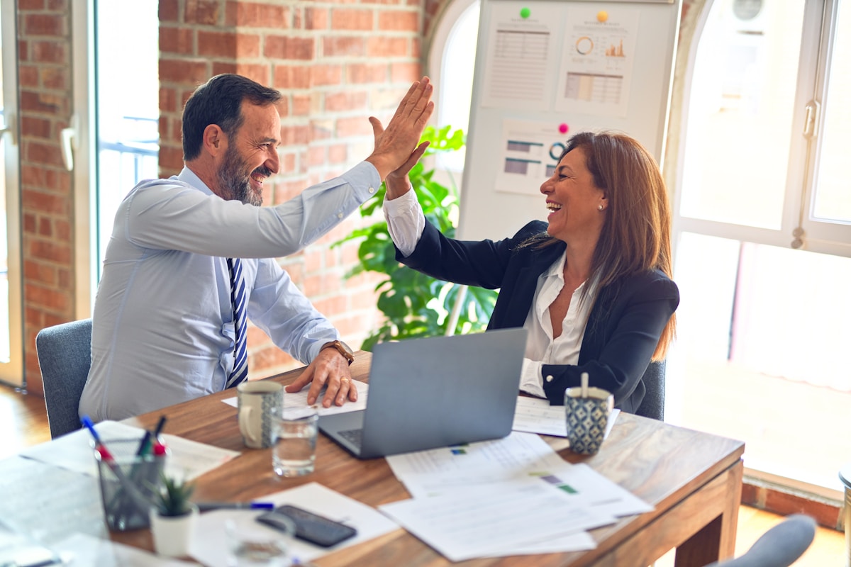 Business owner and advisor reviewing cash flow projections on a laptop